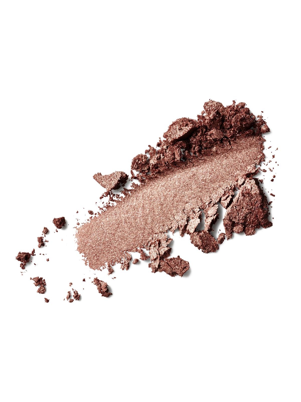 Zerbröselter, schimmernder, brauner Lidschatten auf weißem Hintergrund.