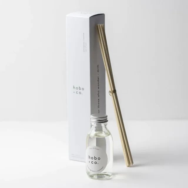 Hobo+Co Raumduft-Set mit Glasflasche und Bambusstäbchen auf weißem Hintergrund.