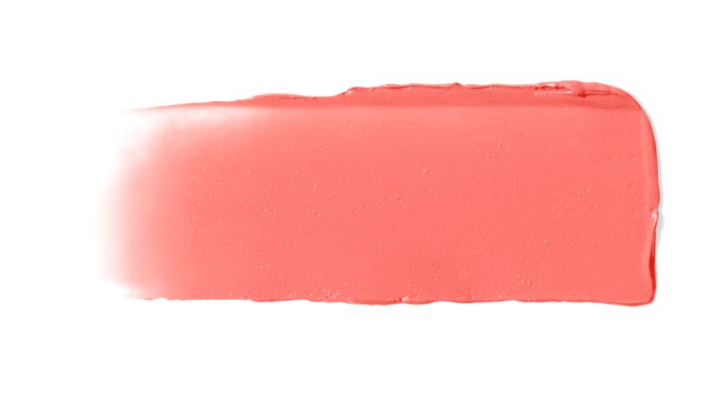 Ein Streifen korallenfarbener Creme-Rouge auf weißem Hintergrund.